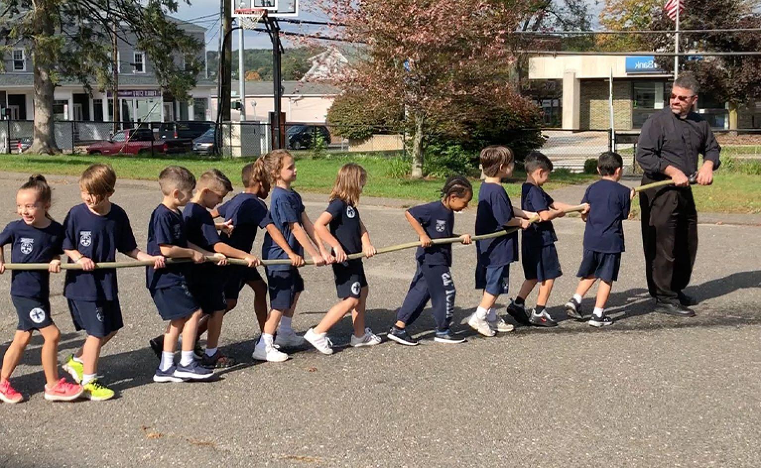 St. John students playing tug of war together with a rope outside