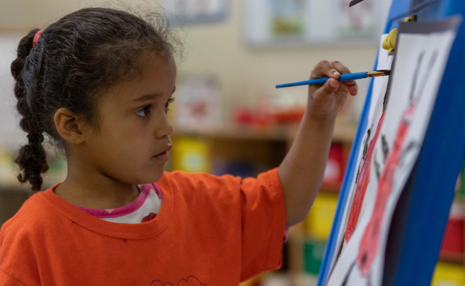 St. John student painting on an easel 